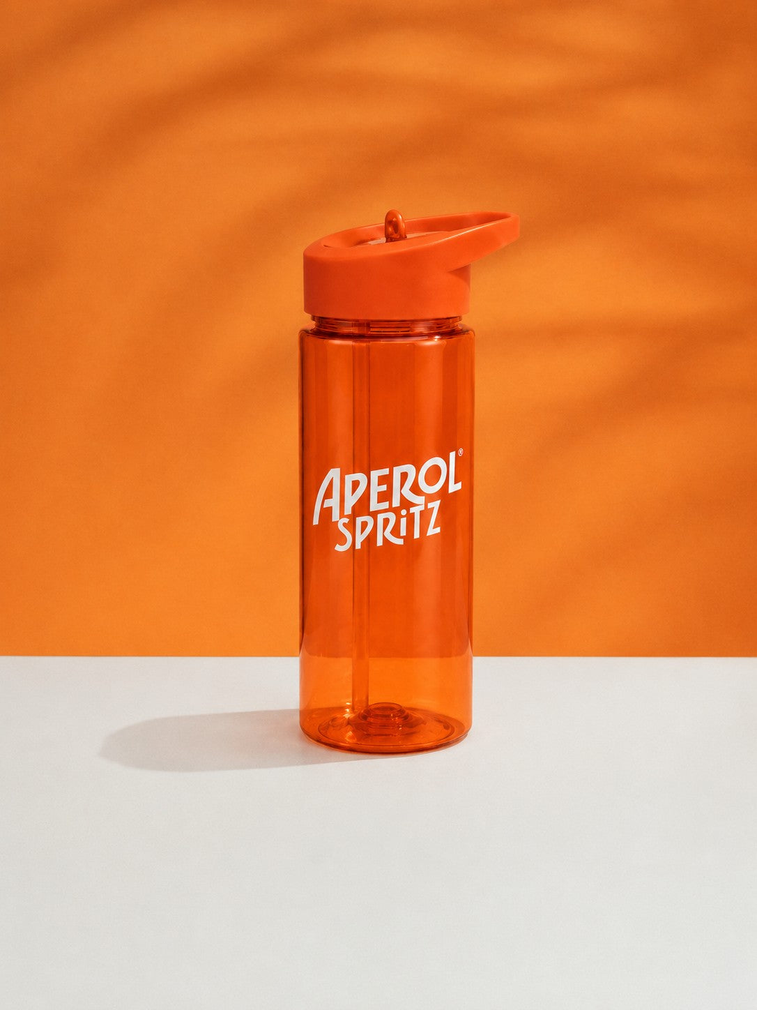 Orange plastic water with straw lid
bottle with 'Aperol Spritz' branding on an orange background