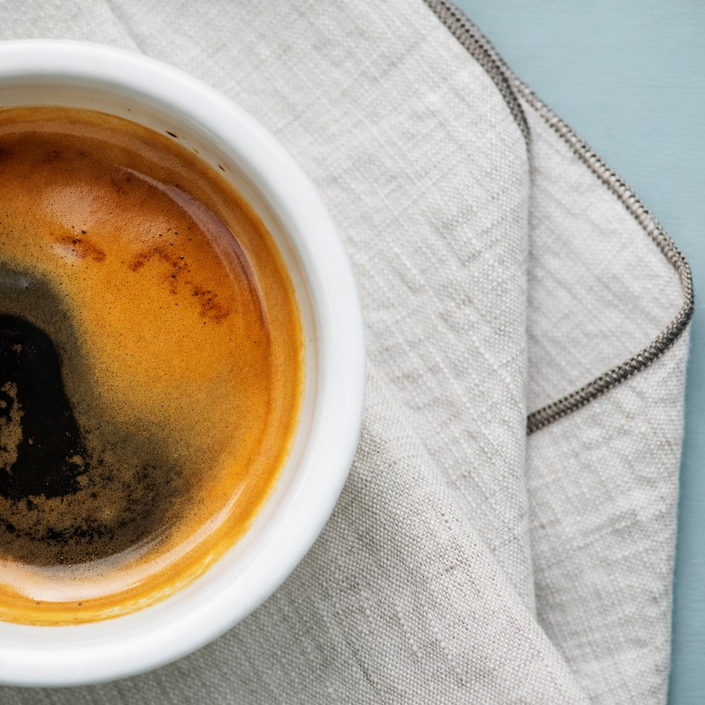 Thick rimmed espresso cup on a linen towel