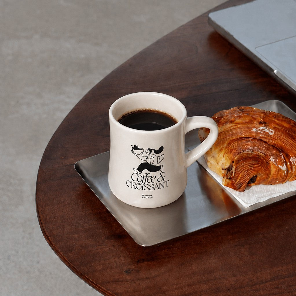 Custom logo diner mug on a metal tray next to a pastry