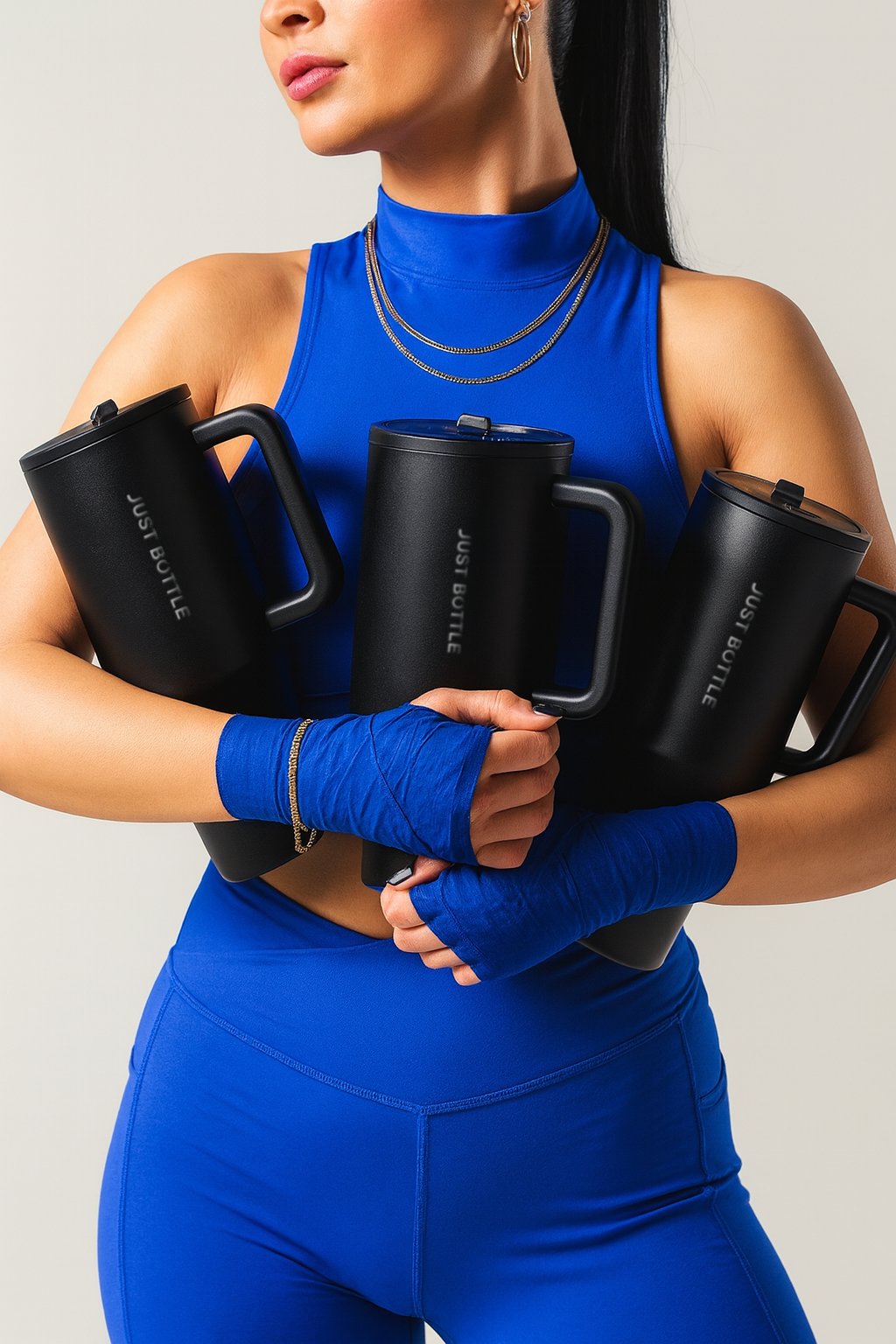 woman in sportswear holding 40oz insulated tumblers with straw lids