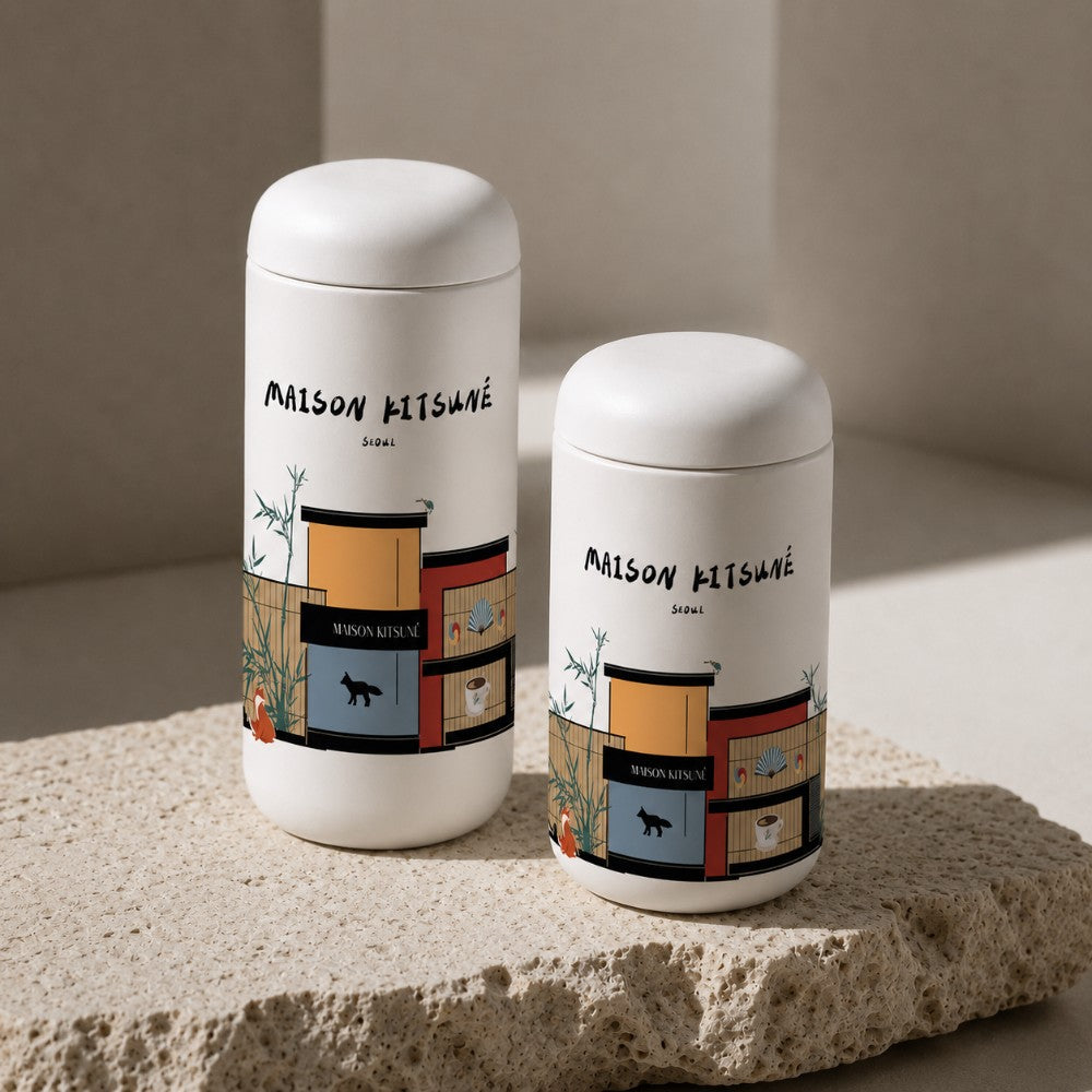 two custom logo leakproof tumblers from Just Bottle with wrap around printing, on a stone with a neutral background