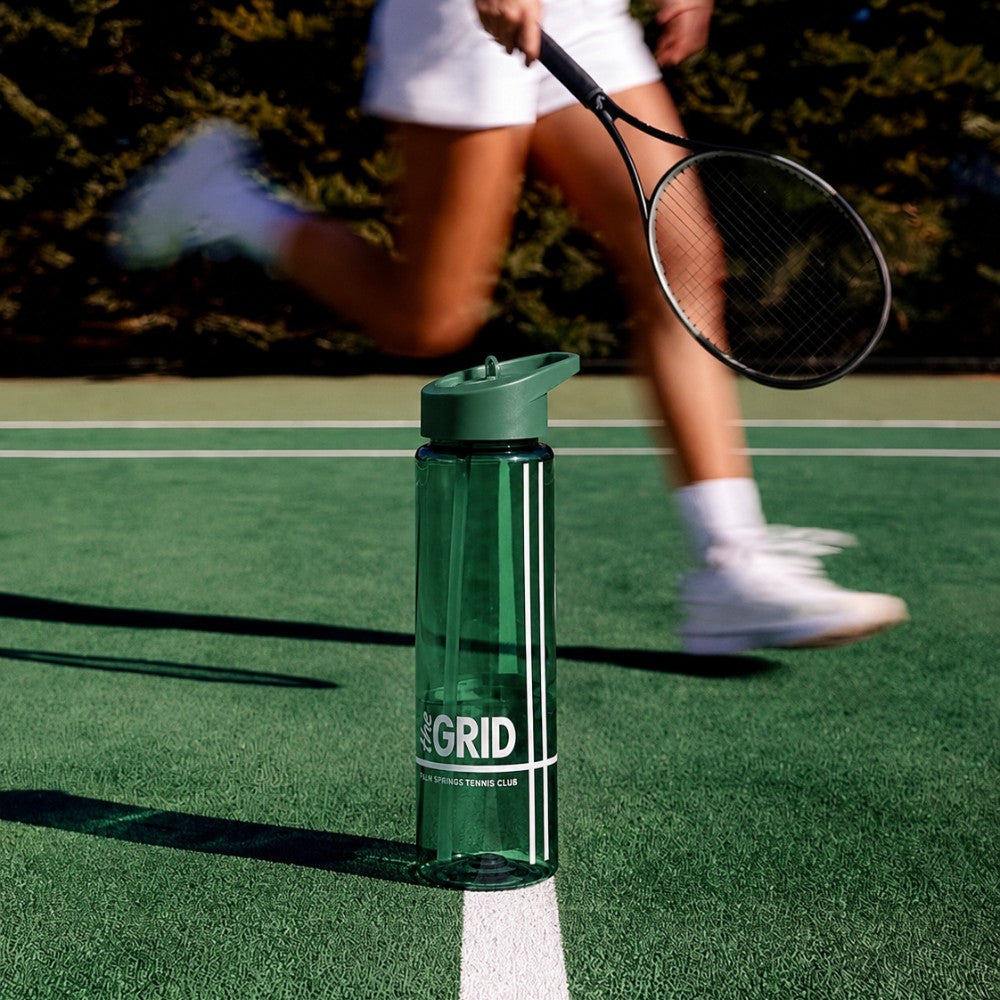 Custom recycled plastic bottle with straw lid on a tennis court