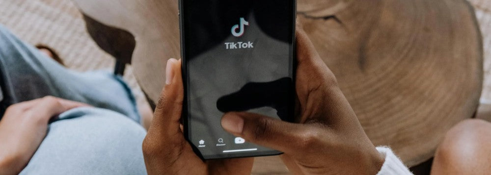Person holding a phone with the TikTok app on screen