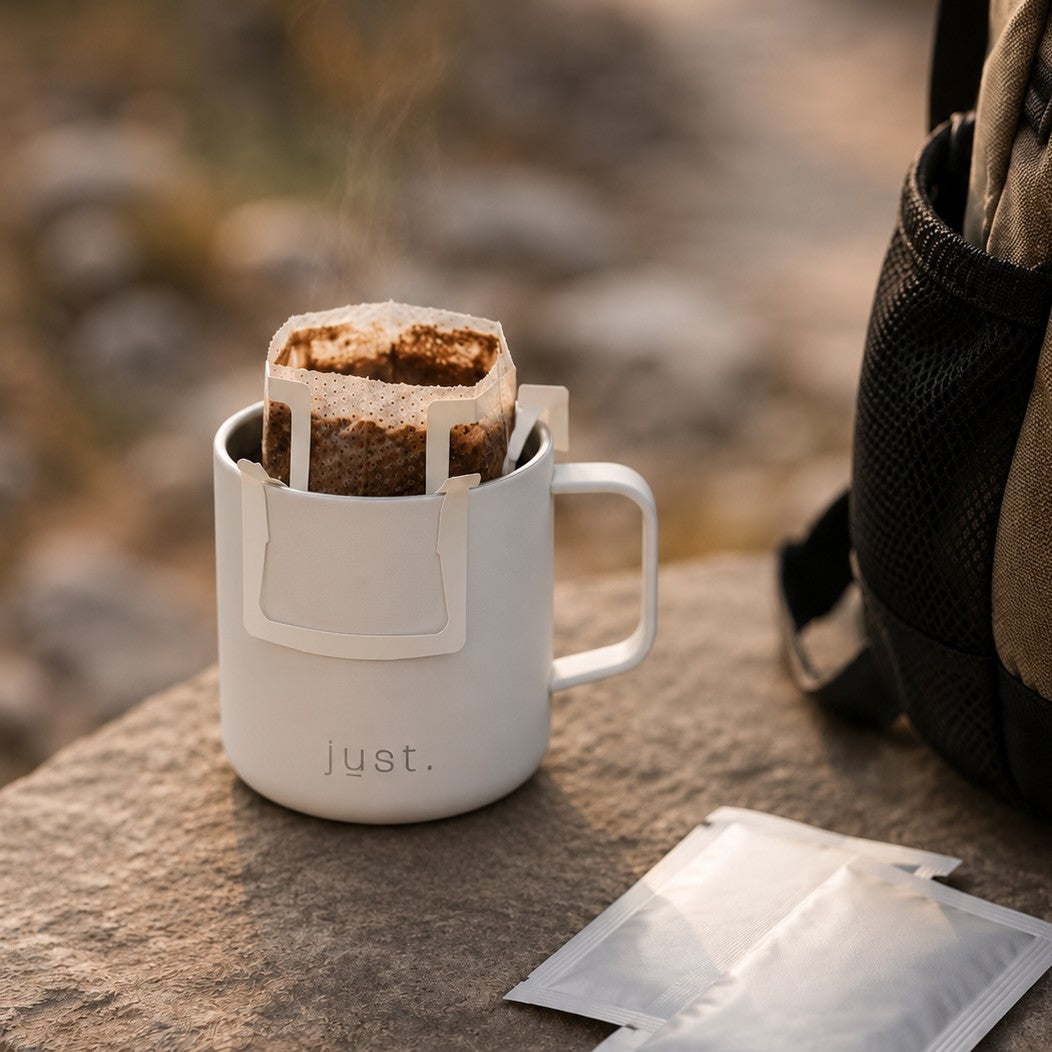 white 10oz insulated camp mug on a rock with a coffee filter bag inside