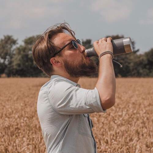 gingerlytravels drinking from Just Bottle lightweight reusable water bottle in summer