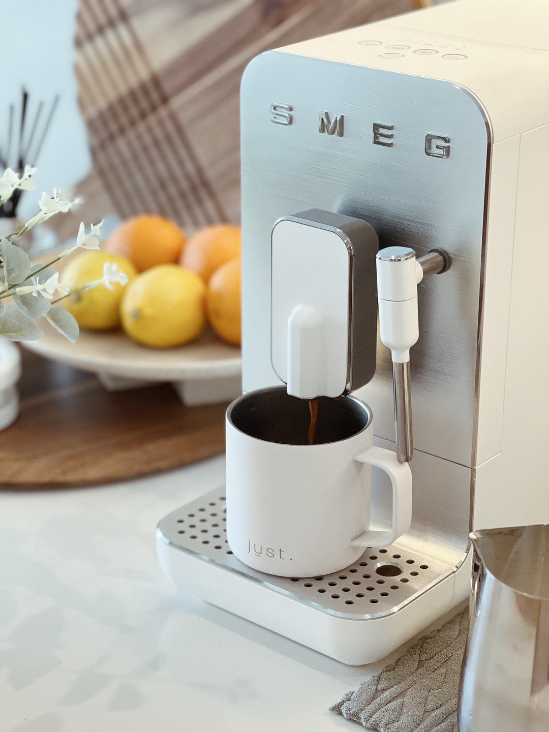 white mug and white smeg coffee machine