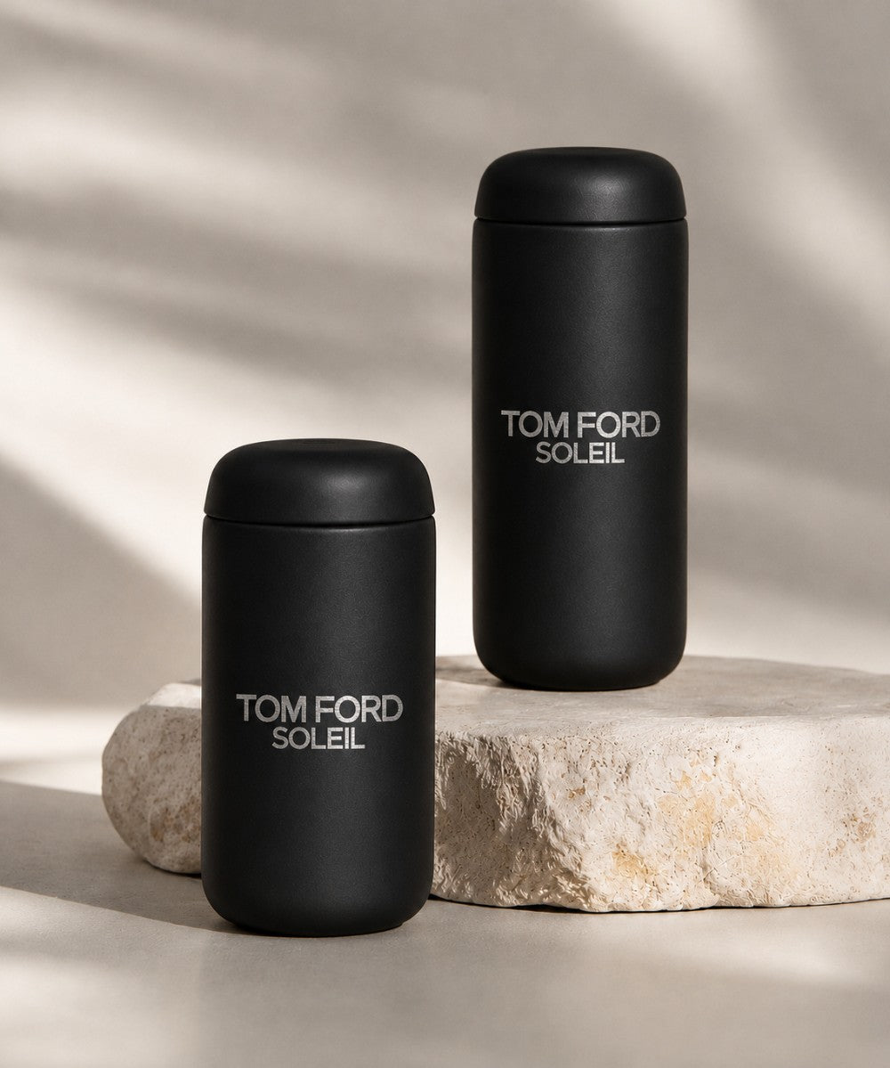Tom Ford branded leakproof tumblers on a rock with a plain background