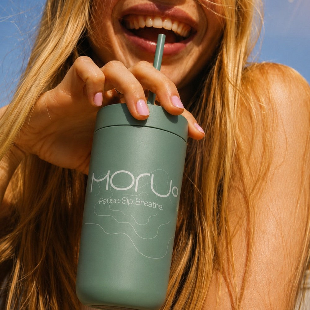 lady holding a green custom branded tumbler with straw lid