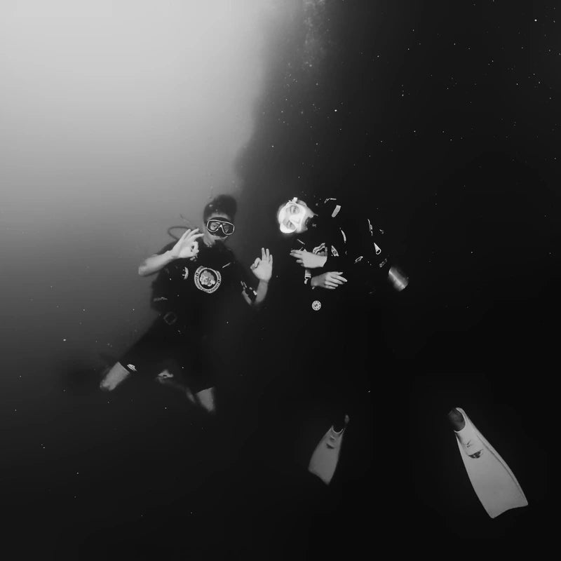 man and woman scuba diving together