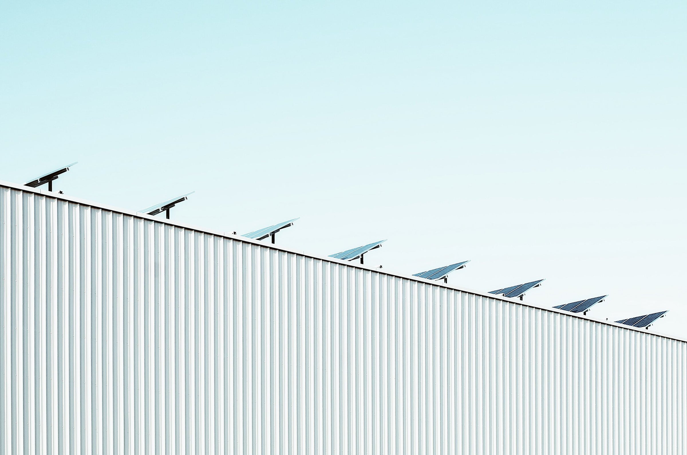 Warehouse roof with solar panels and blue sky