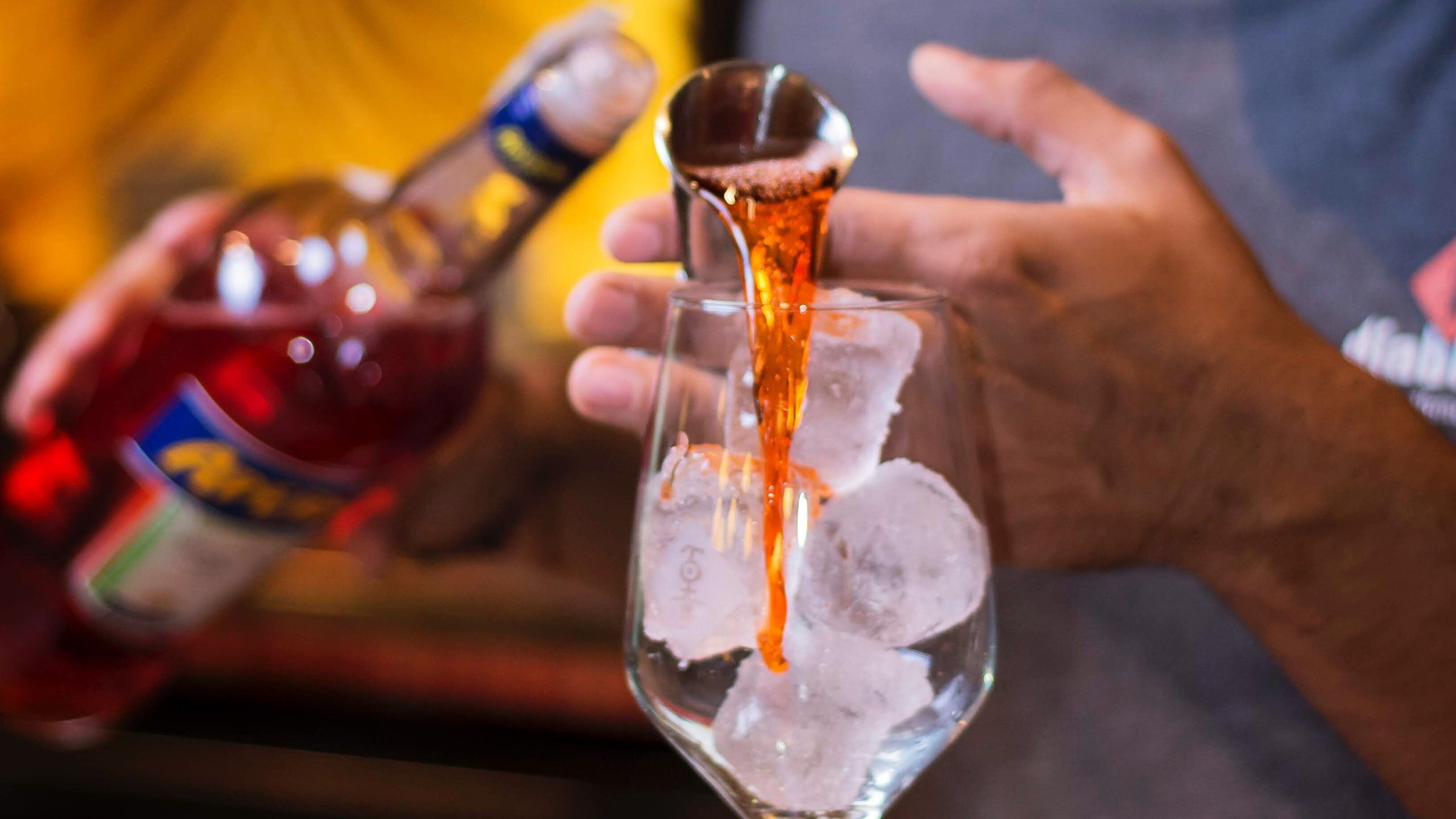 pouring aperol into an iced glass