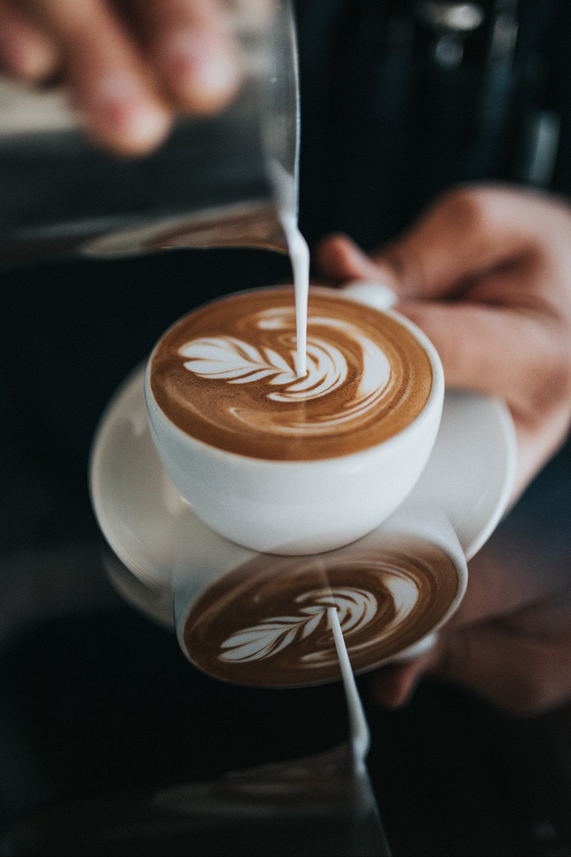 barista pouring a flat white coffee