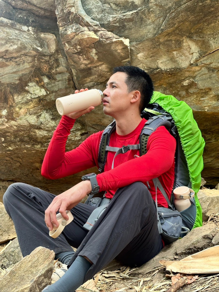 hiker drinking from a large water bottle