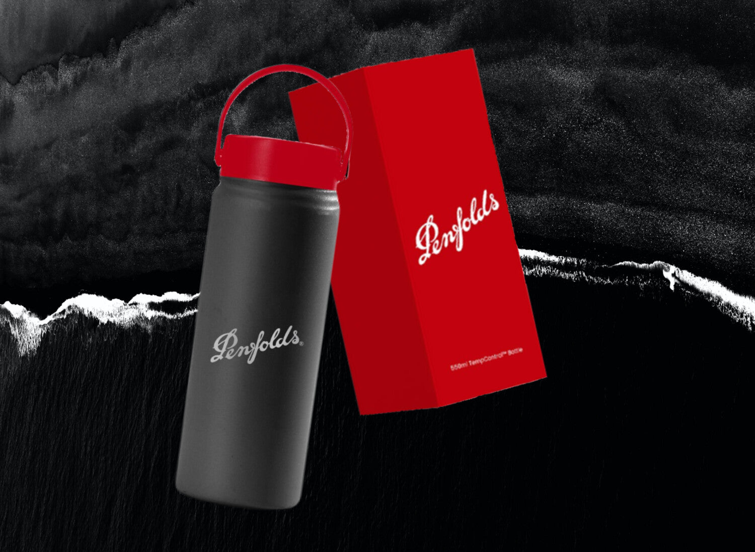 black 550ml custom branded thermal water bottle with Penfolds logo laser engraved next to custom branded red packaging box with a black beach behind 