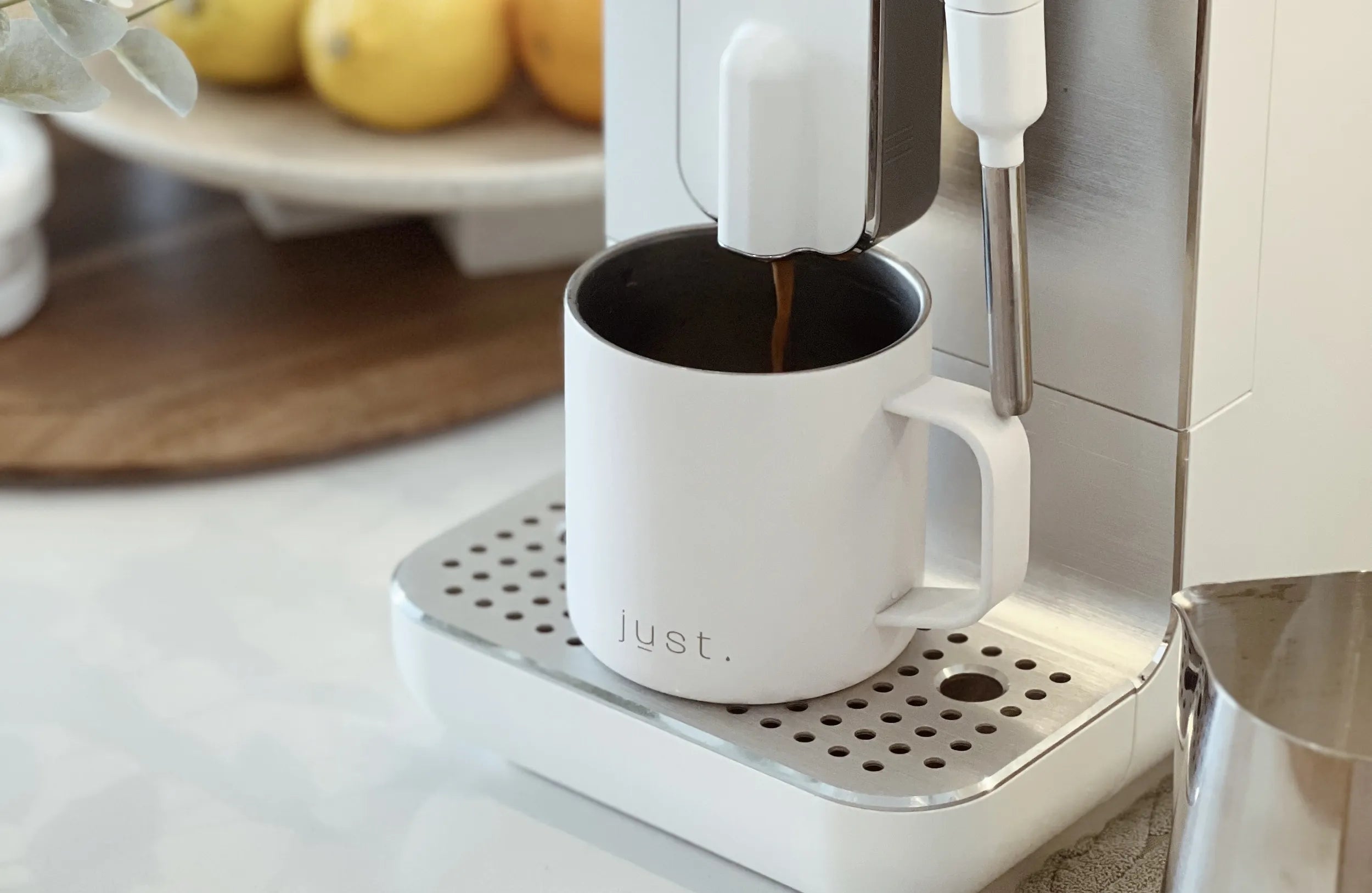 white reusable coffee mug under coffee machine
