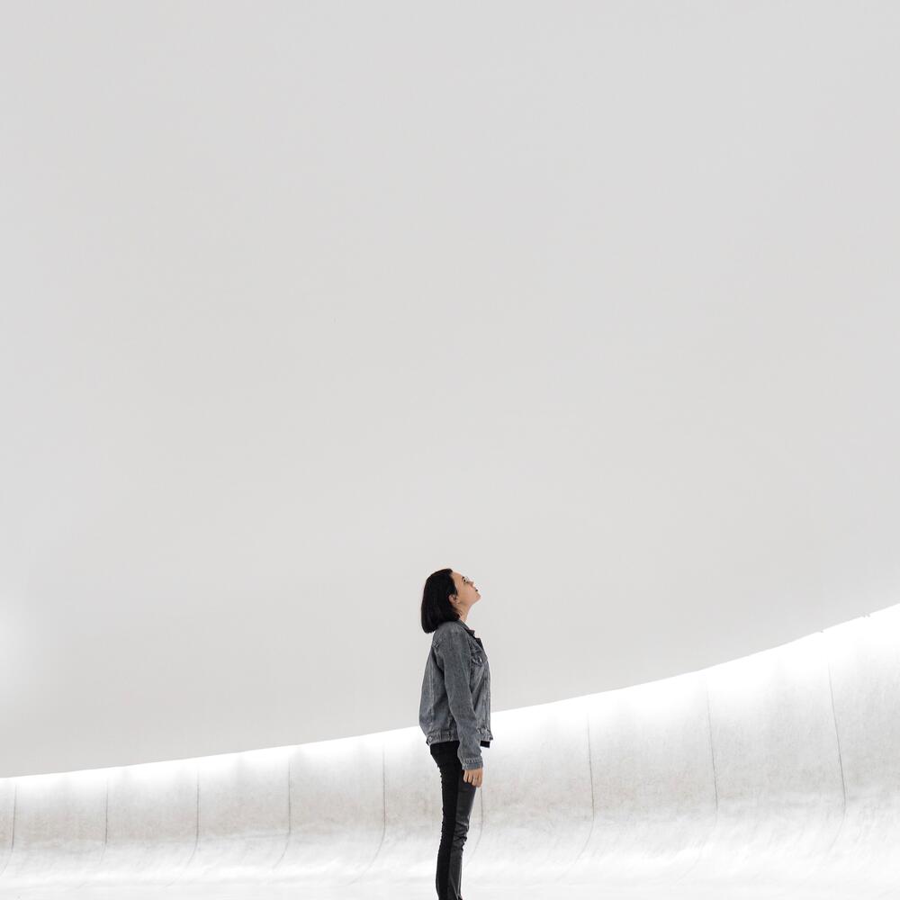 person looking up at plain white wall 