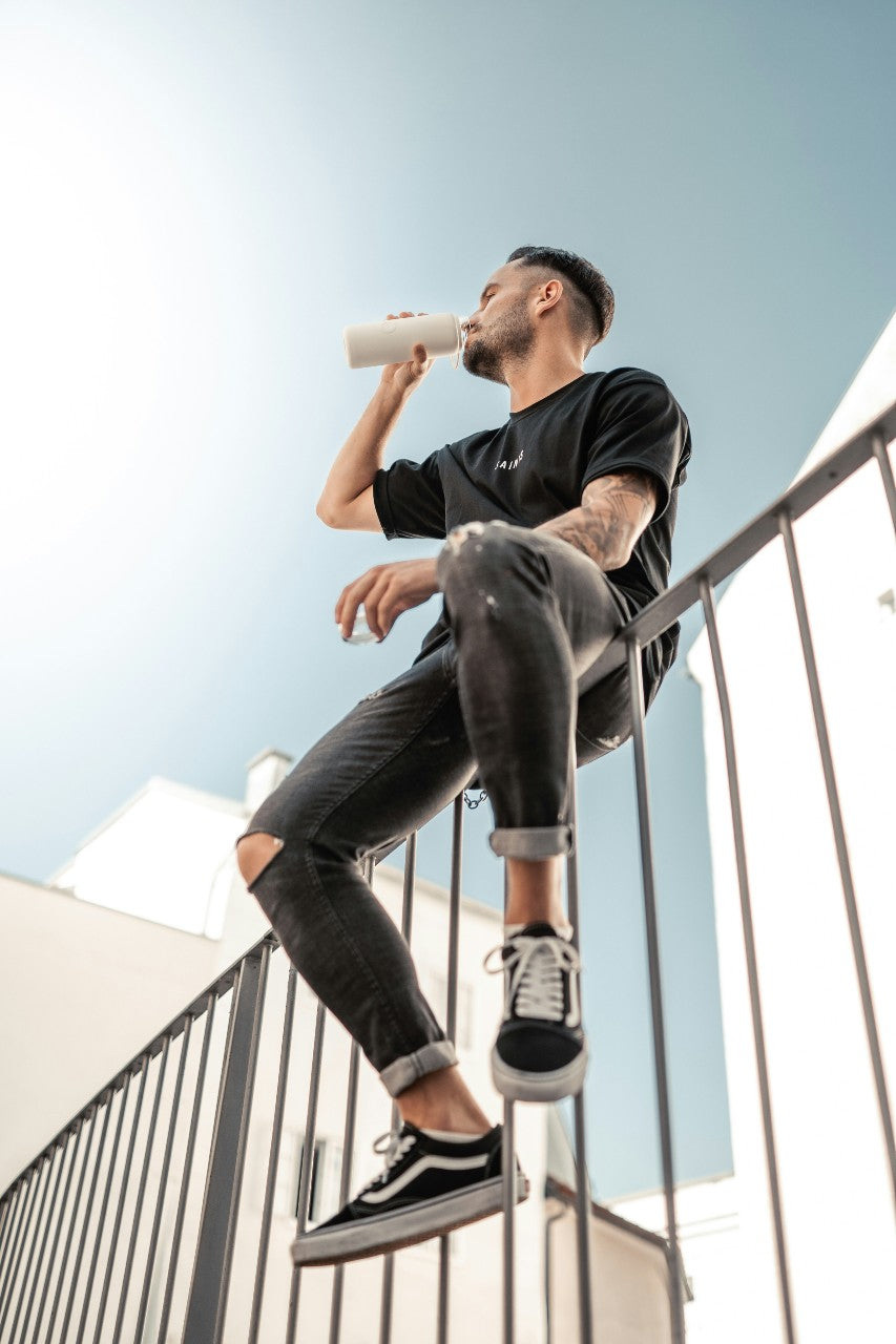 man drinking from insulated water bottle