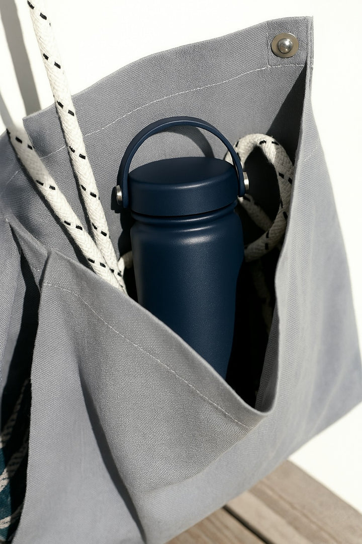 dark water bottle in a canvas bag