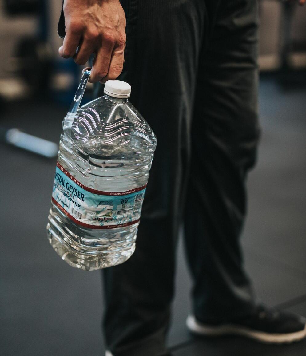Man holding large plastic bottle in right hand