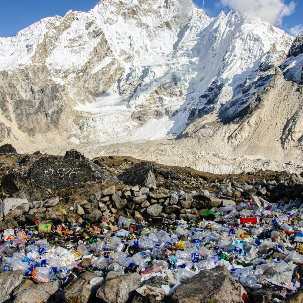 plastic water bottles thrown away on rocks in front of a mountain