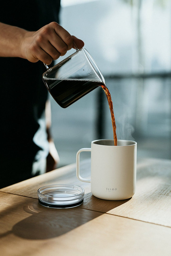 pouring hot coffee into a white 12oz reusable coffee mug - stainless steel design
