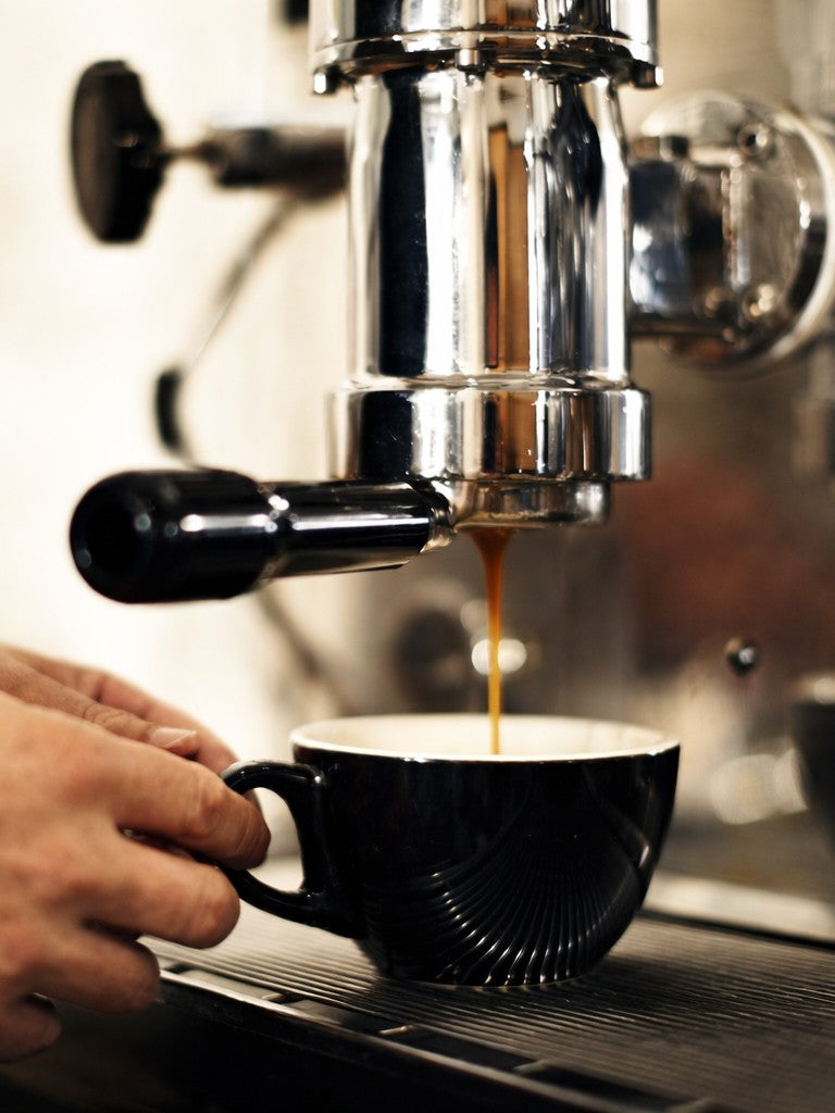 Smooth glazed coffee cup under coffee machine