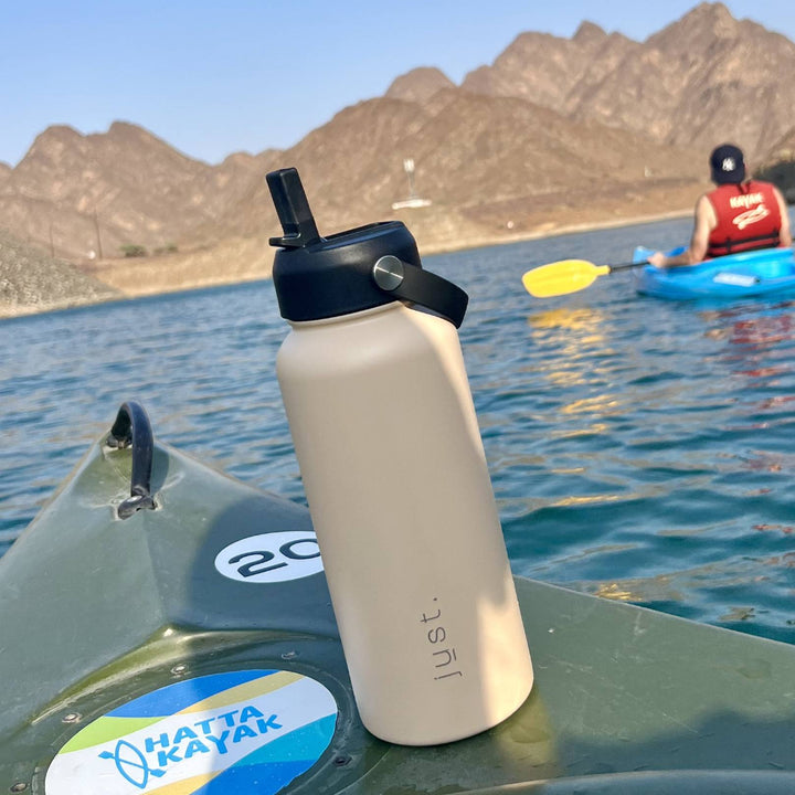 insulated water bottle with straw lid on a kayak