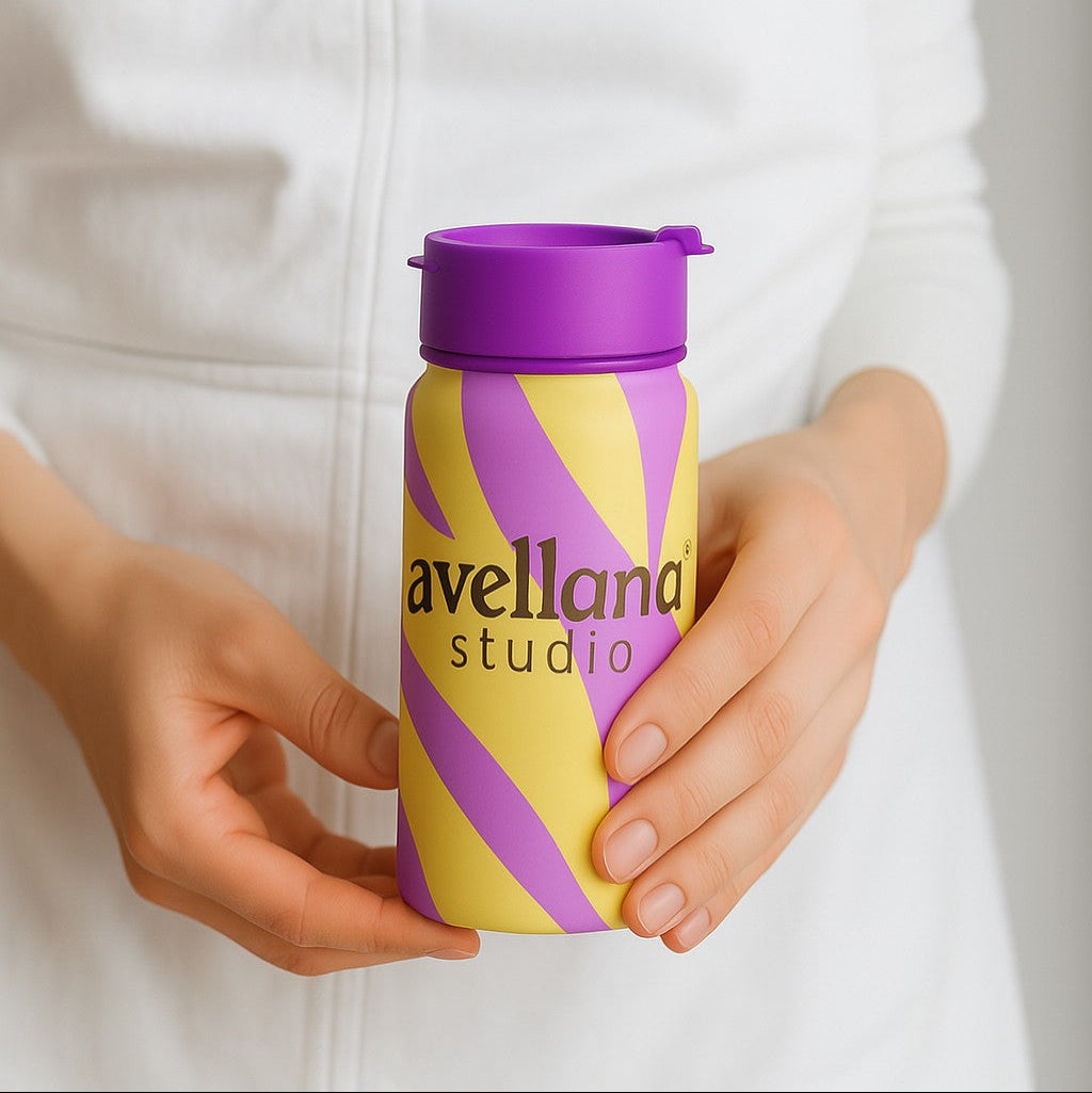 Person holding a colorful travel mug with a  company logo